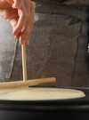 woman-cooking-delicious-crepe-electrical-pancake-maker-kitchen-closeup